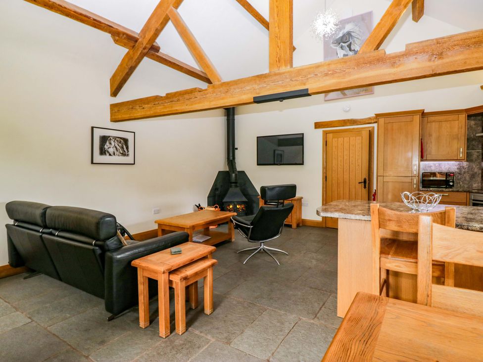 A living room with a fireplace and seating area at Yew Tree Cottage in Torver
