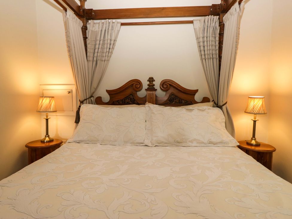 A bedroom with a bed and lamps at Yew Tree Cottage in Torver
