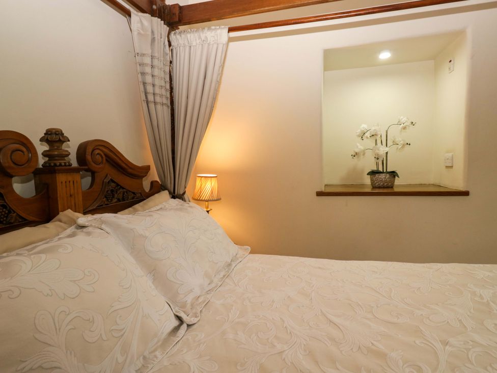 A bedroom with a bed and a lamp at Yew Tree Cottage in Torver