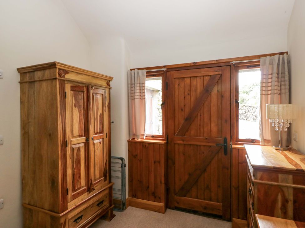 An entryway with a wardrobe and wooden door at Yew Tree Cottage in Torver