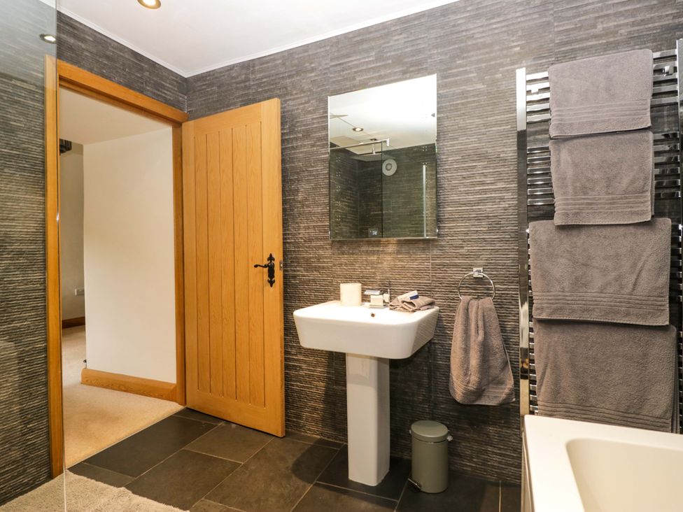 A bathroom with a sink and towels at Yew Tree Cottage in Torver