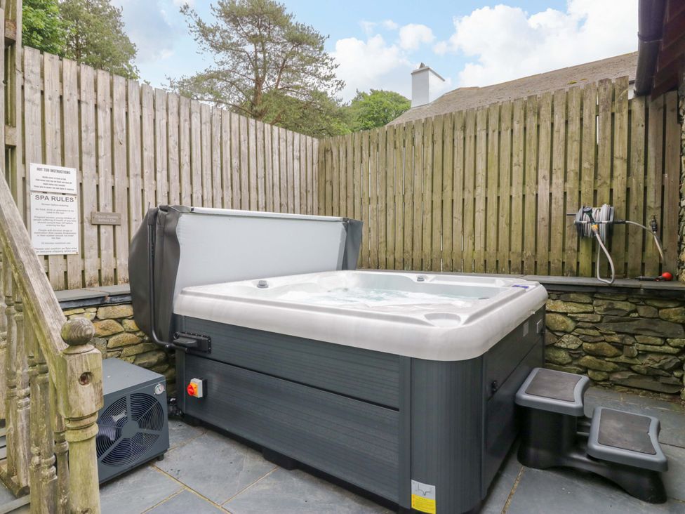 An outdoor hot tub with a sign and steps at Yew Tree Cottage in Torver
