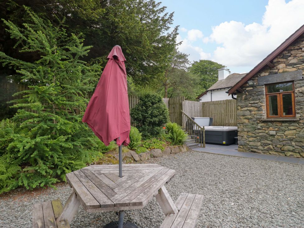 An outdoor space with a table and umbrella at Yew Tree Cottage in Torver