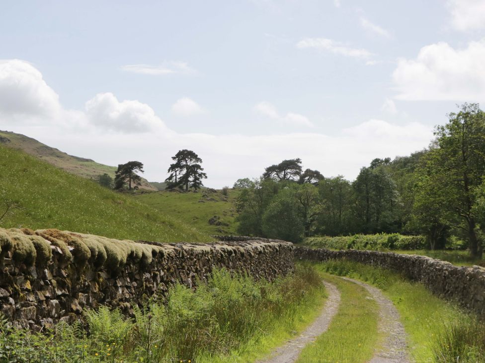 A dirt path between stone walls in a rural area at Yew Tree Cottage in Torver