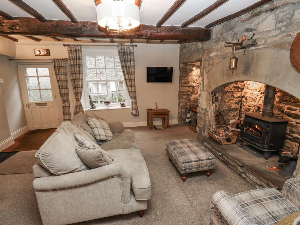 A living room with a fireplace and sofa at Chamber End Fold Grassington