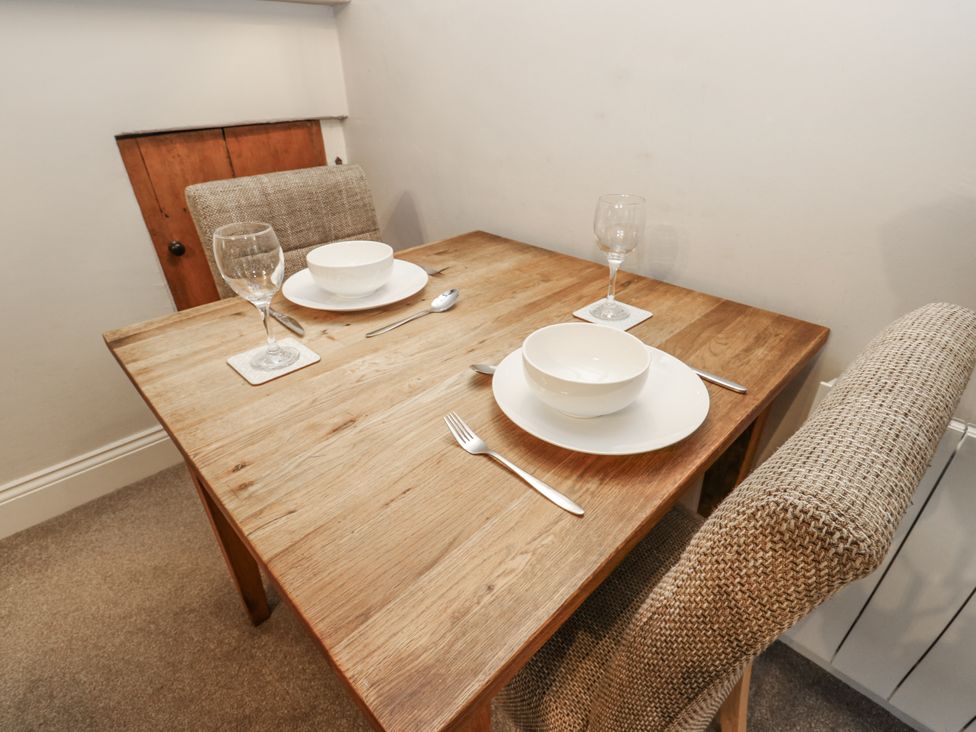 A dining room with a wooden table and two chairs at Chamber End Fold Grassington