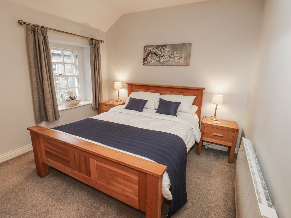 A bedroom with a bed and bedside tables at Chamber End Fold in Grassington