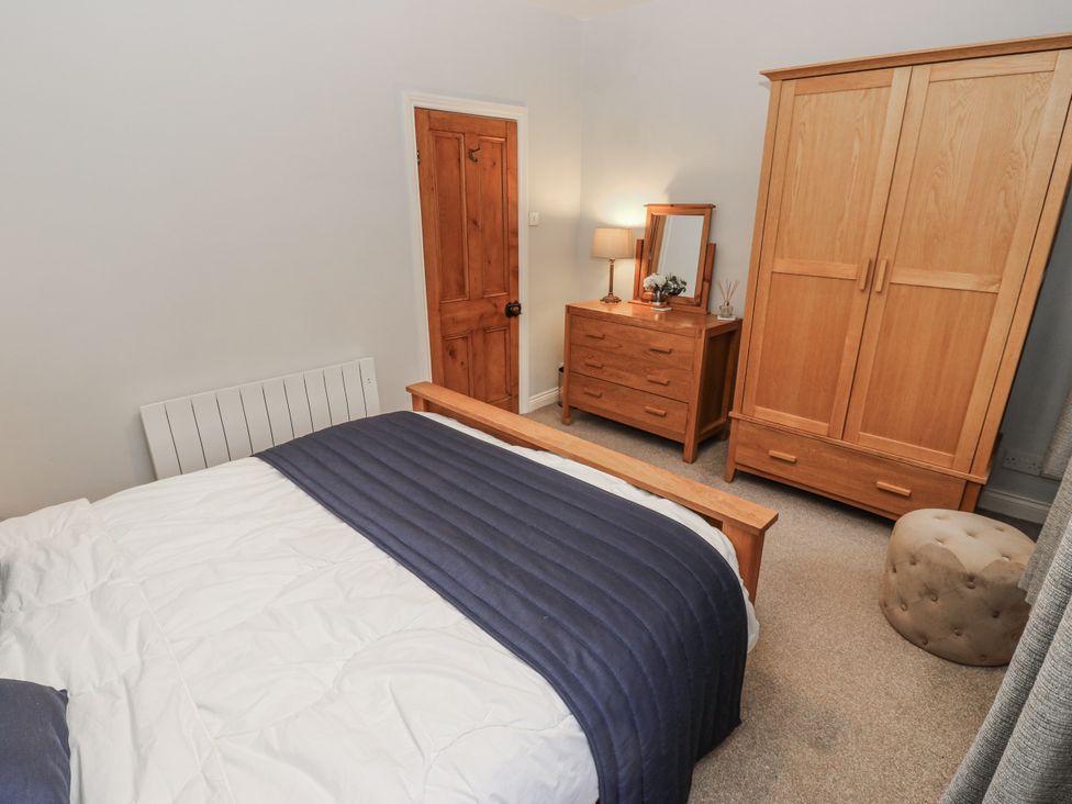 A bedroom with a bed, wardrobe, and dresser at Chamber End Fold in Grassington