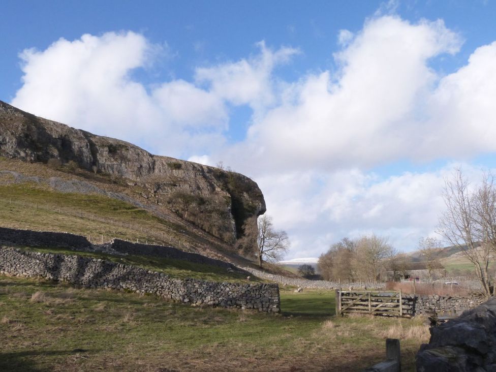 A landscape with a rock formation and trees at Chamber End Fold Grassington