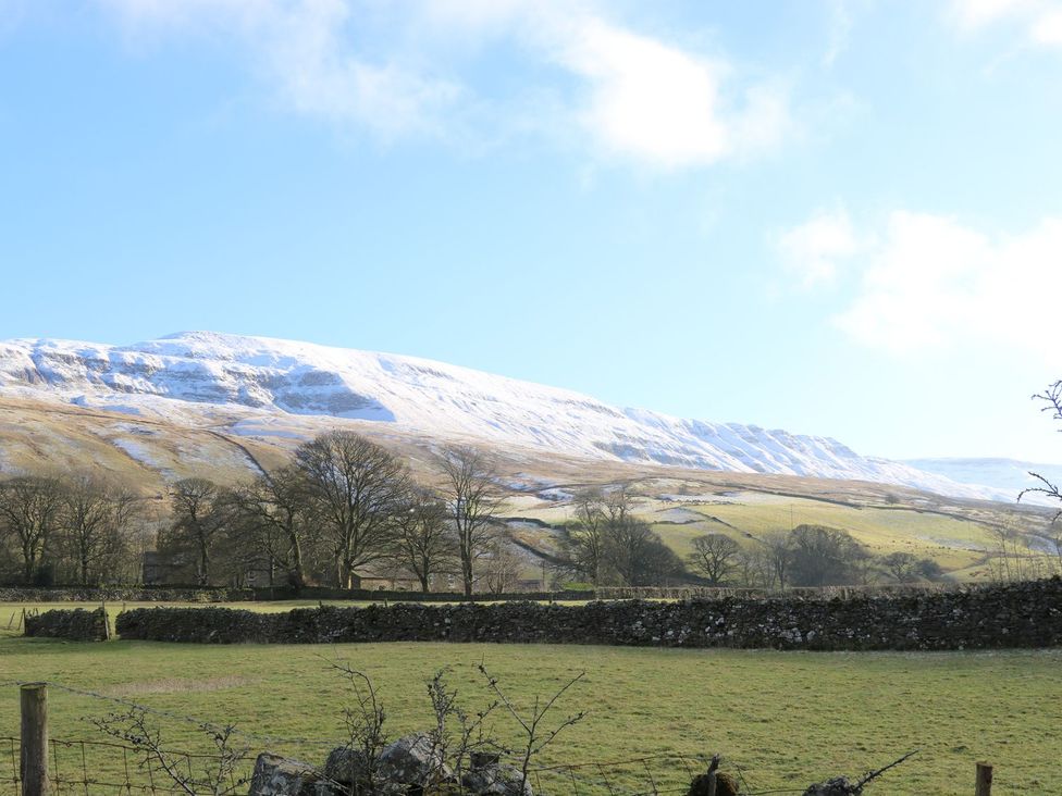 A view of mountains with snow and a field at Chamber End Fold in Grassington
