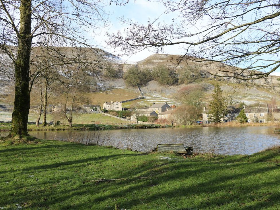 A scenic view of houses near a lake at Chamber End Fold in Grassington