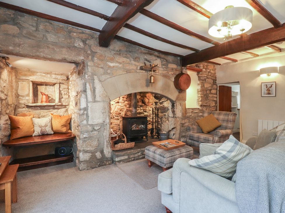 A living room with a fireplace and seating area at Chamber End Fold Grassington