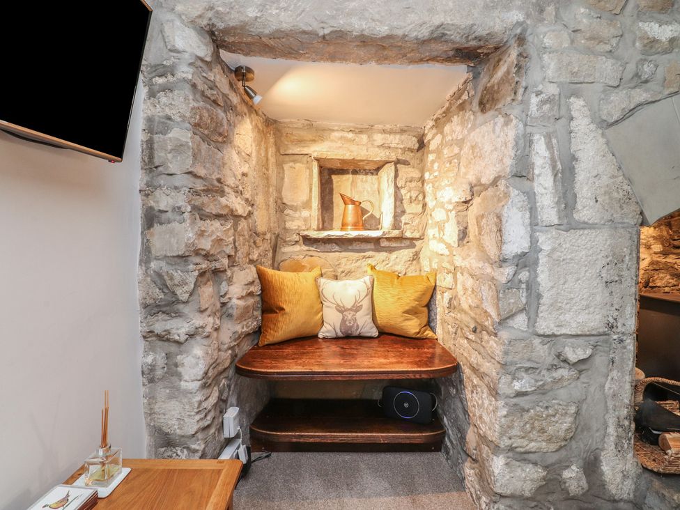A snug with stone walls and a wooden bench at Chamber End Fold in Grassington