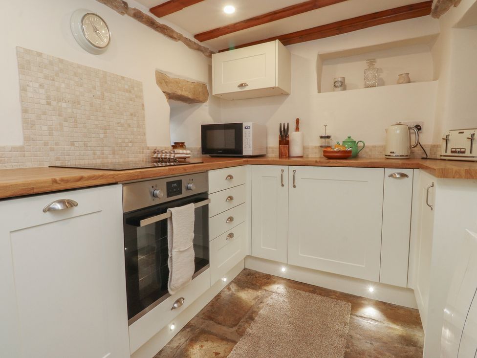 A kitchen with cabinets and appliances at Chamber End Fold Grassington
