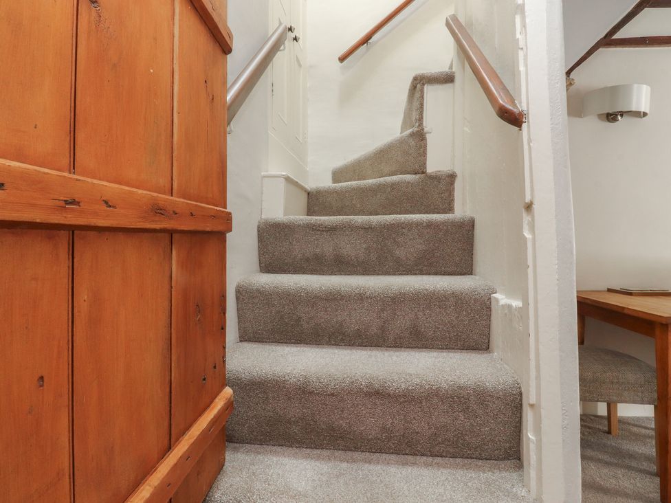 A staircase with a handrail and a nearby table and chair at Chamber End Fold Grassington