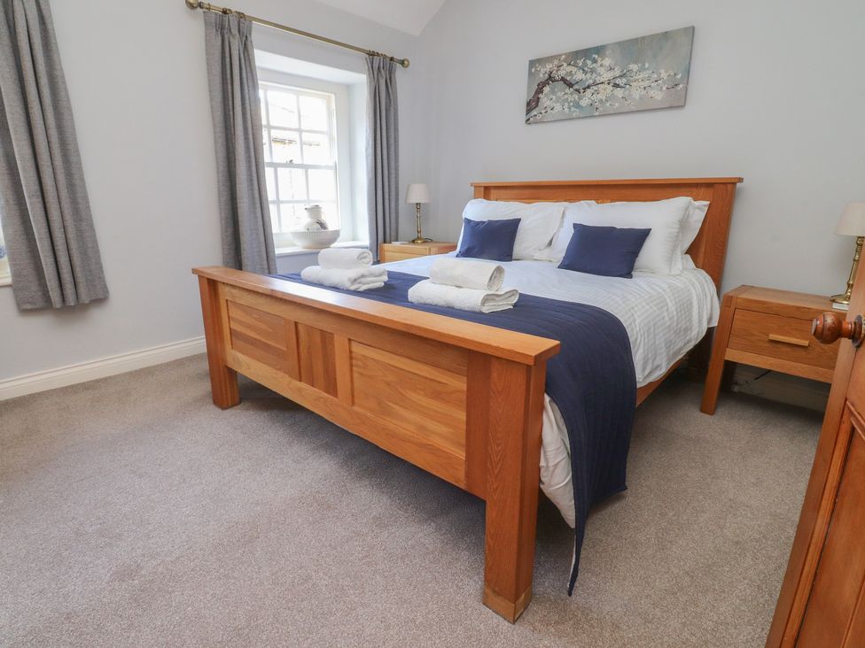 A bedroom with a wooden bed and nightstand at Chamber End Fold Grassington