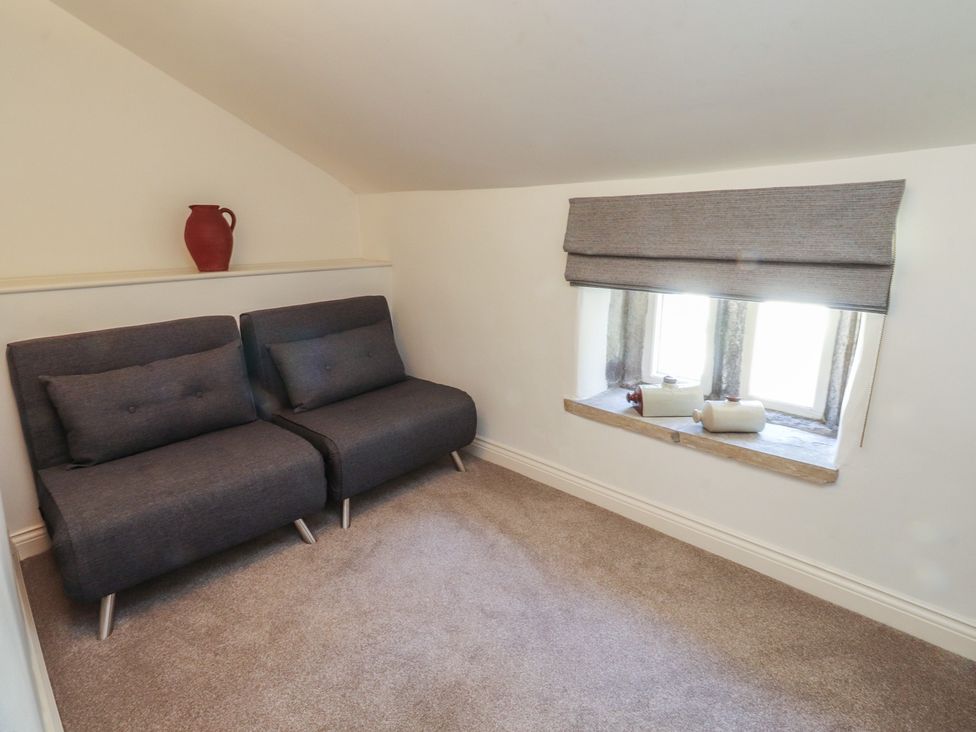 A small living room with couches and a window at Chamber End Fold in Grassington