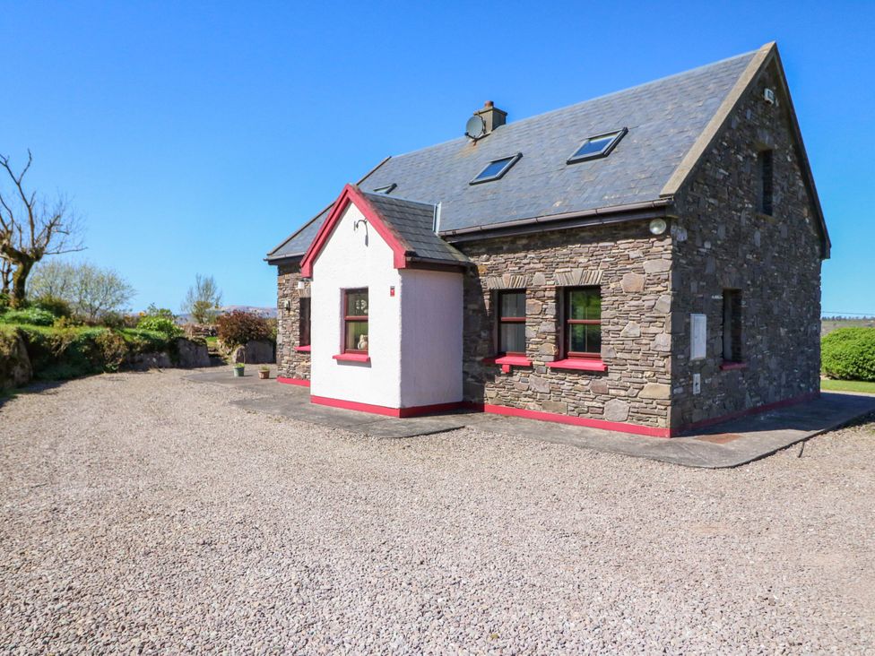 A house with stone walls and a gravel driveway at Stone Cottage in Waterville, County Kerry