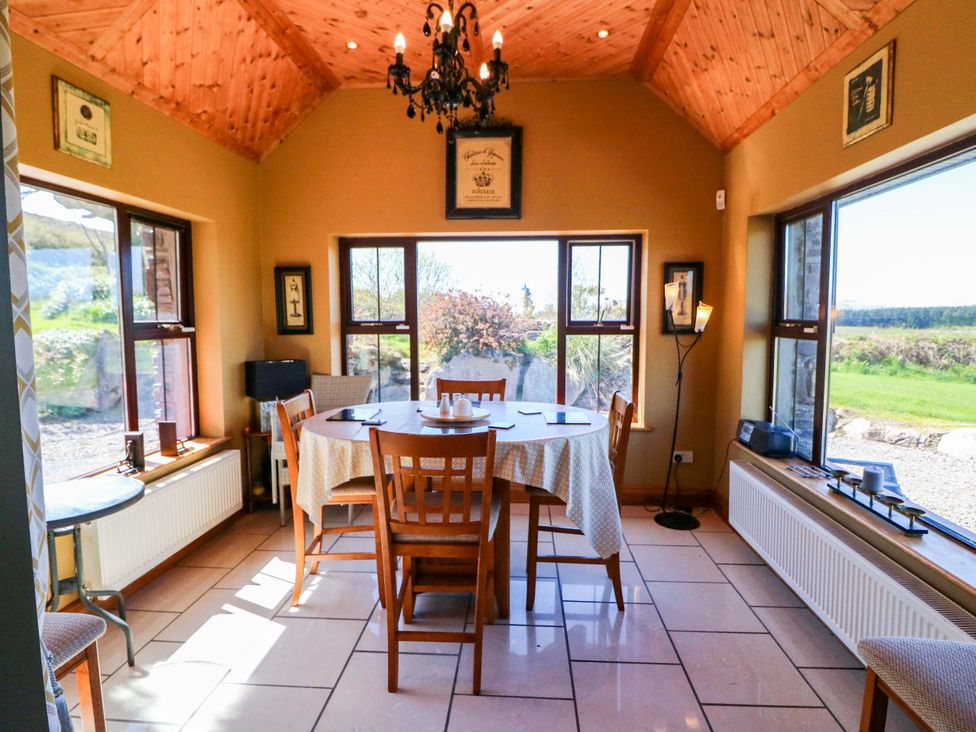 A dining room with a table and chairs at Stone Cottage, Waterville, County Kerry