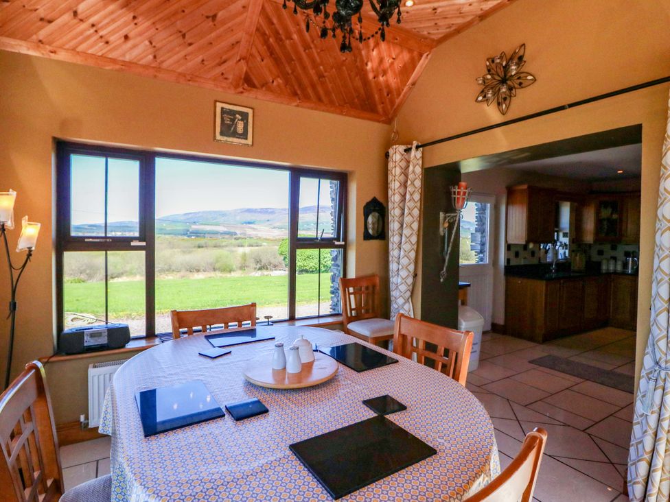 A dining room with window views and a table set at Stone Cottage in Waterville, County Kerry