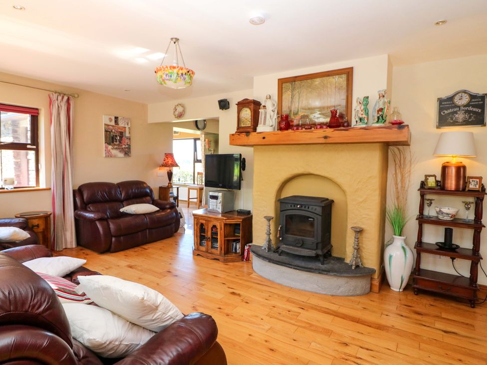 A living room with a fireplace and sofa at Stone Cottage in Waterville, County Kerry
