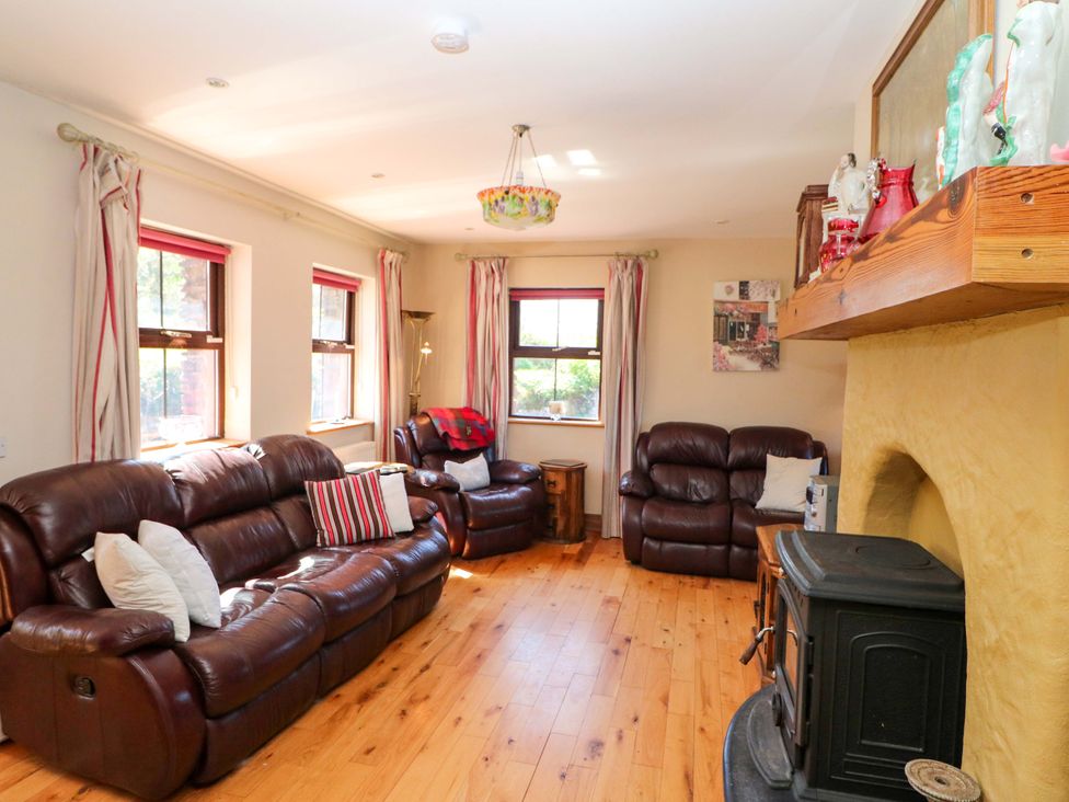 A living room with sofas and a fireplace at Stone Cottage in Waterville, County Kerry