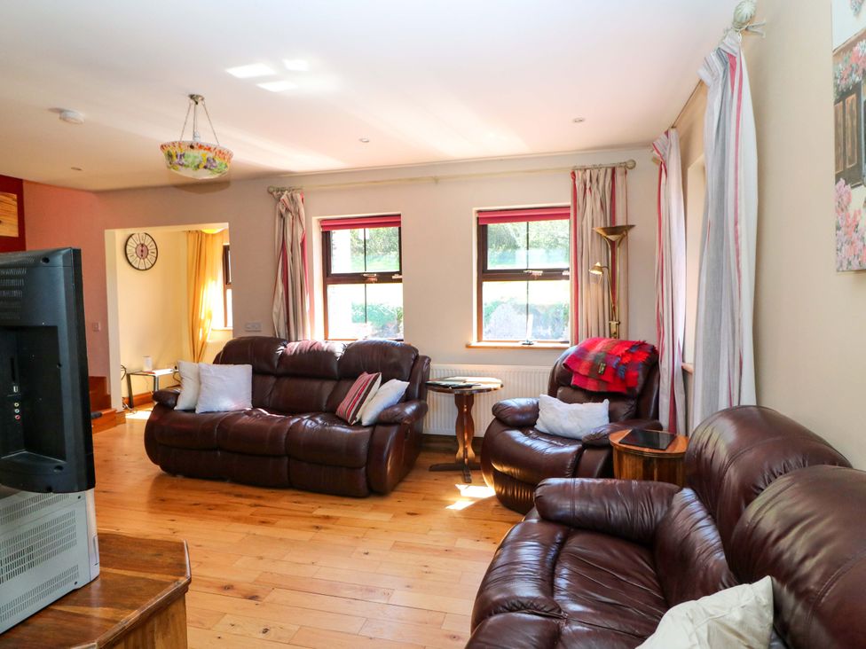 A living room with sofas and a television at Stone Cottage in Waterville, County Kerry