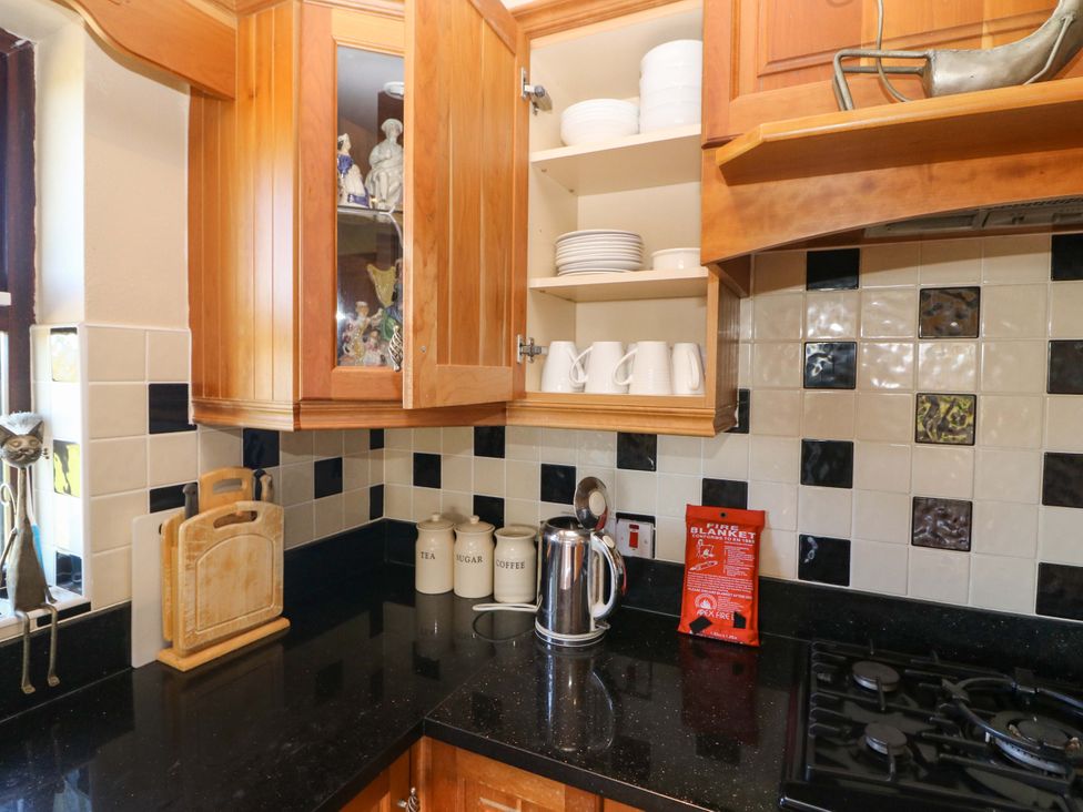 A kitchen with a cabinet and counter space at Stone Cottage in Waterville, County Kerry