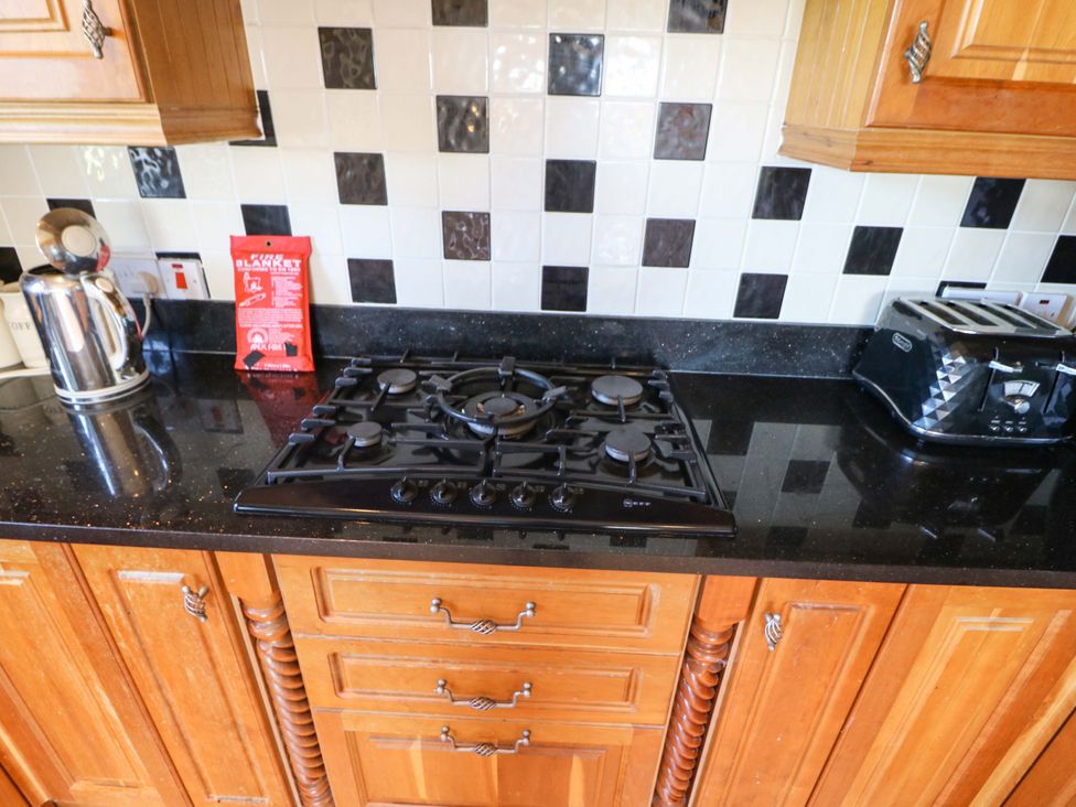 A kitchen with a gas stove and toaster at Stone Cottage in Waterville, County Kerry