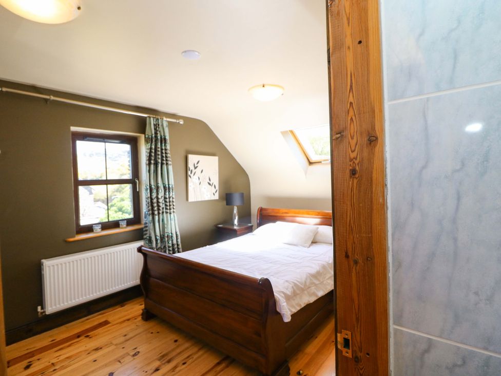 A bedroom with a bed and window at Stone Cottage in Waterville, County Kerry
