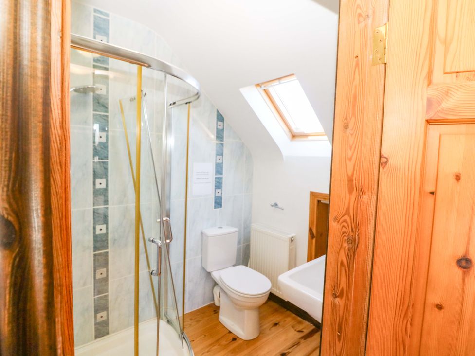 A bathroom with a shower and toilet at Stone Cottage Waterville, County Kerry
