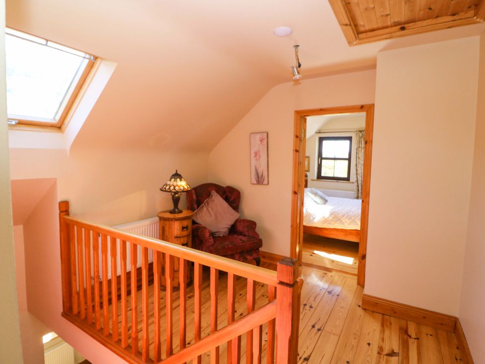 A landing with a chair and lamp at Stone Cottage in Waterville, County Kerry