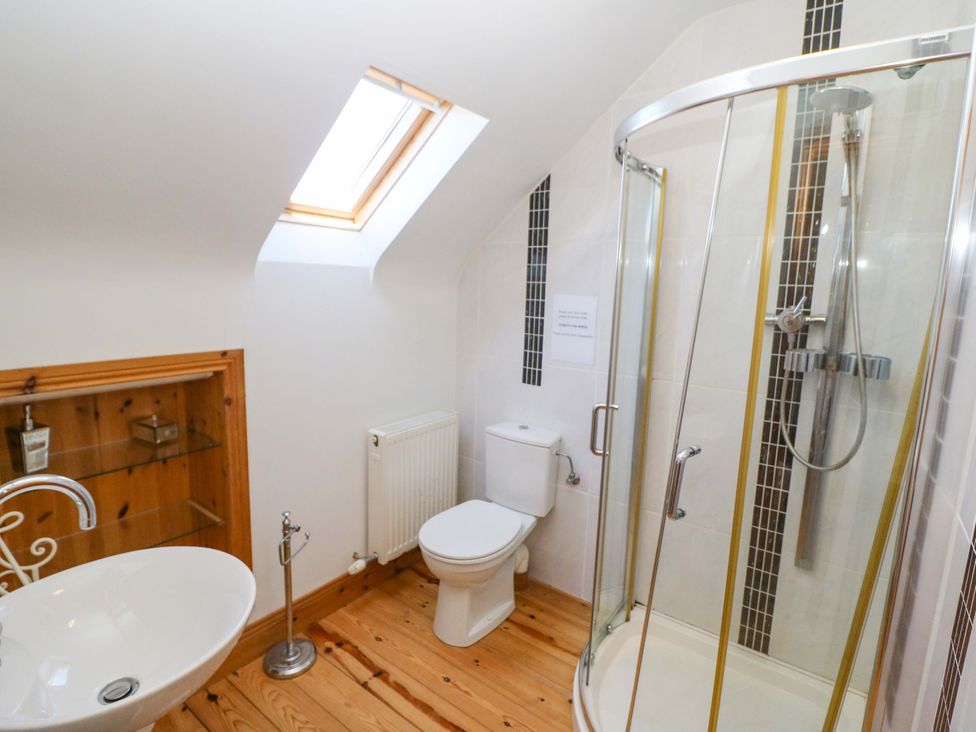 A bathroom with a shower and bathtub at Stone Cottage in Waterville, County Kerry