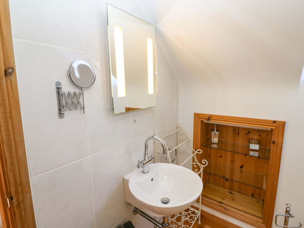 A bathroom with sink and mirror at Stone Cottage in Waterville, County Kerry