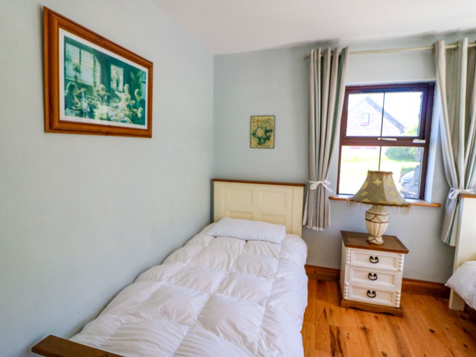 A bedroom with a single bed and a nightstand at Stone Cottage in Waterville, County Kerry