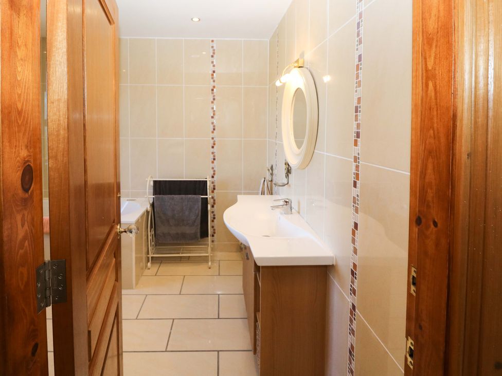 A bathroom with a sink and a towel rack at Stone Cottage in Waterville, County Kerry