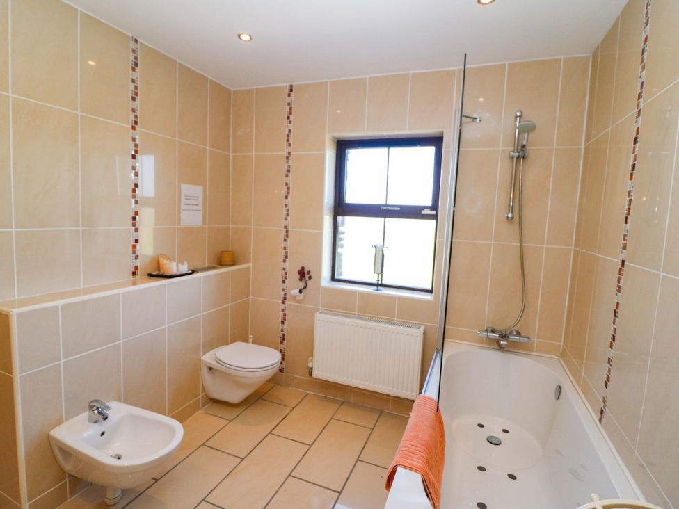 A bathroom with a shower and bathtub at Stone Cottage in Waterville, County Kerry
