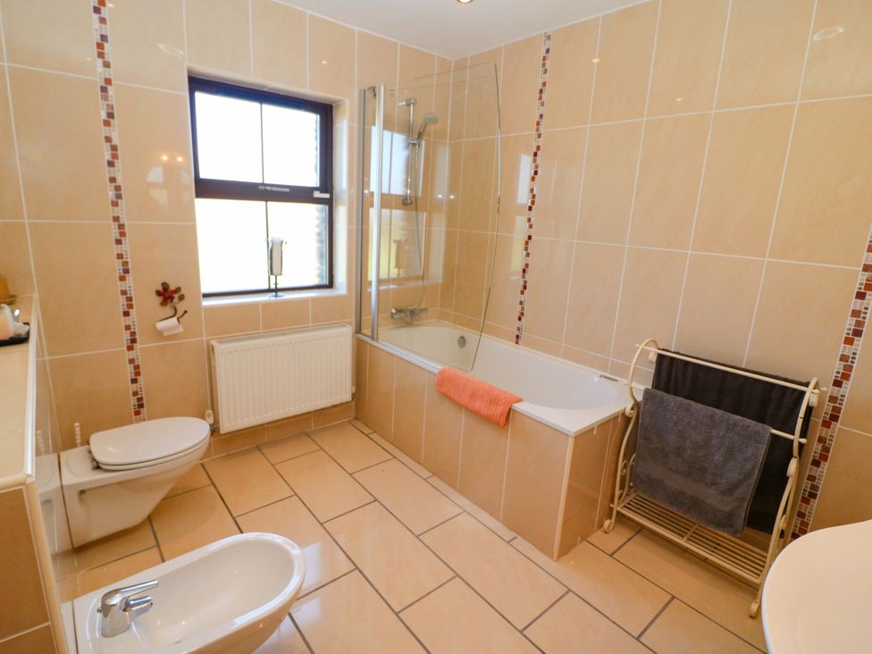A bathroom with a bathtub and toilet at Stone Cottage in Waterville, County Kerry