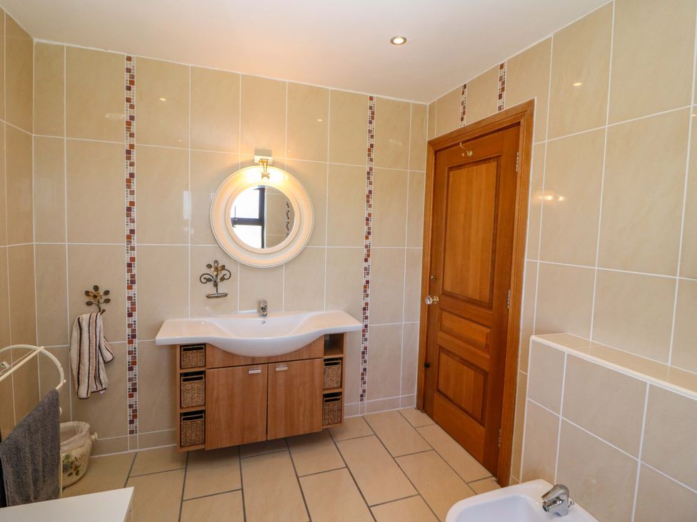 A bathroom with a sink and a mirror at Stone Cottage in Waterville, County Kerry