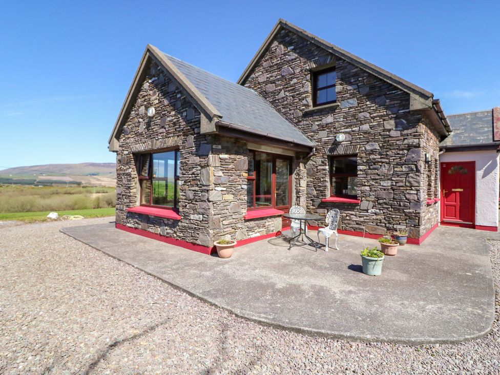 A house with stone exterior and patio furniture at Stone Cottage, Waterville, County Kerry