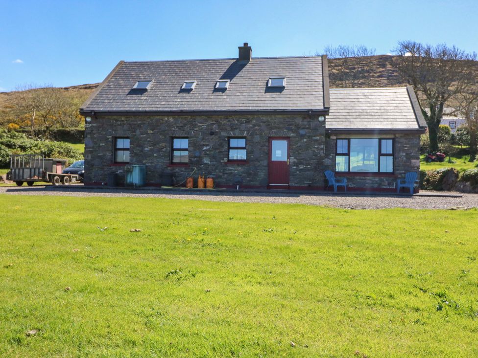 A house with windows and chairs at Stone Cottage in Waterville, County Kerry