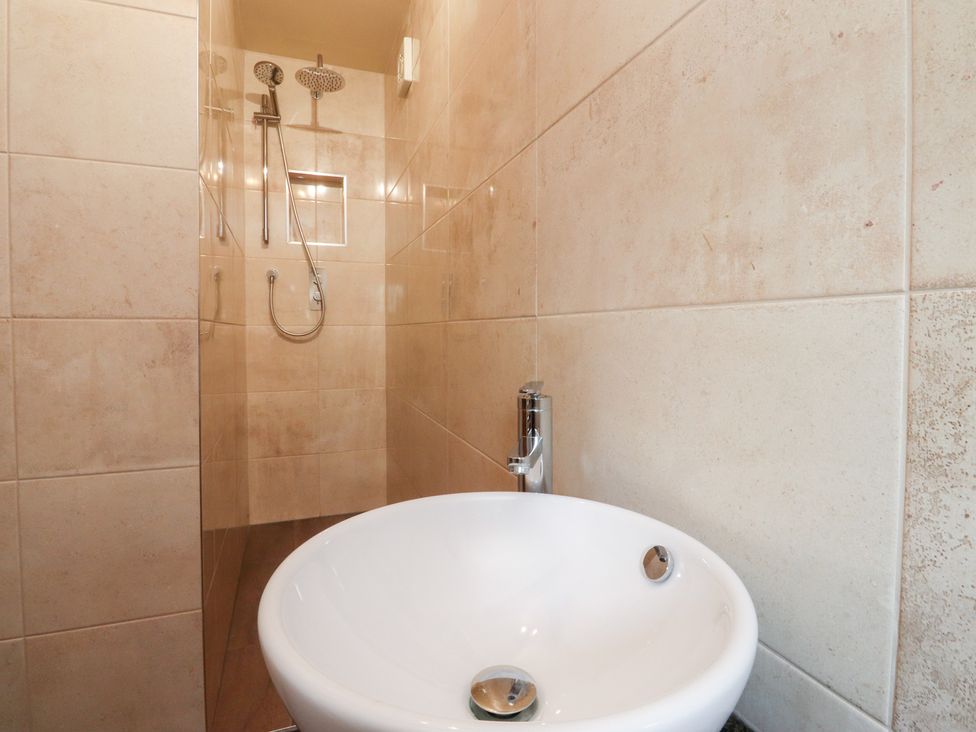 A bathroom featuring a shower and hand basin at Sandywood in Burnsall near Grassington
