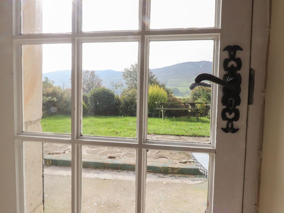 A view through a window showing a garden and mountains at Sandywood in Burnsall near Grassington