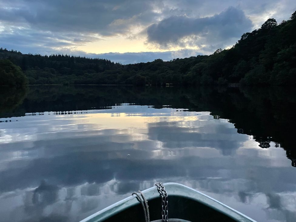 A lake with reflections and a boat at Tafarn Trip in Tan Y Bwlch, Maentwrog