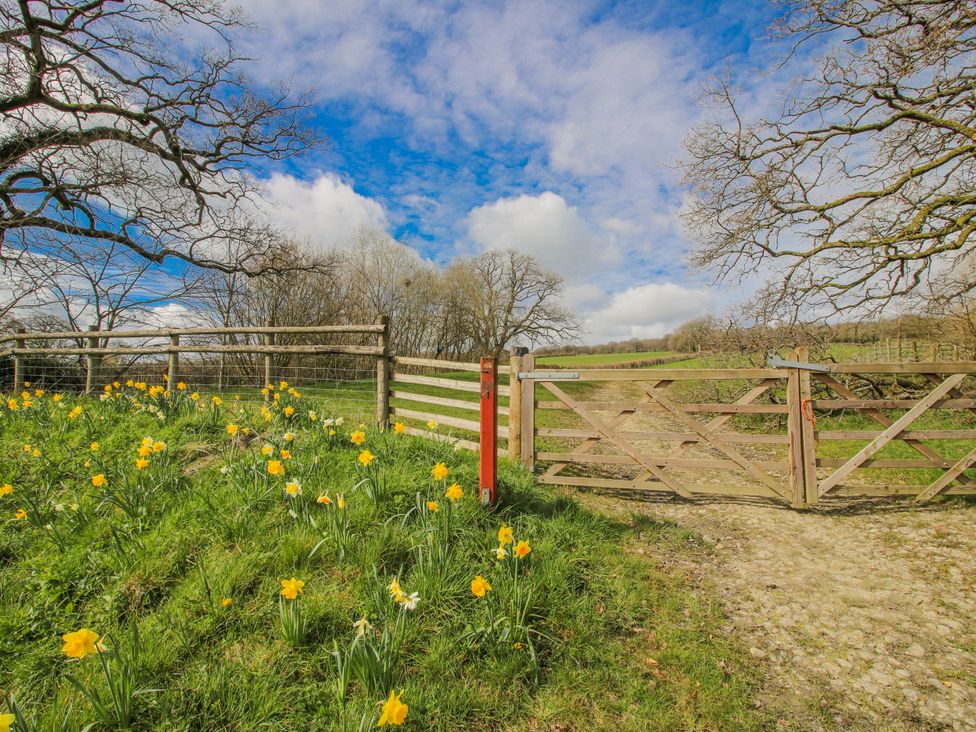 A gate surrounded by flowers and trees at Trooper's Barn in Westhope