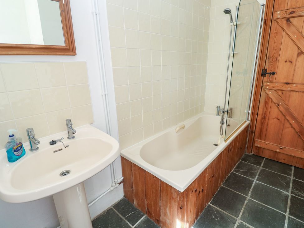 A bathroom with a bath tub and sink at Swallows, St Keverne, Lizard Peninsula