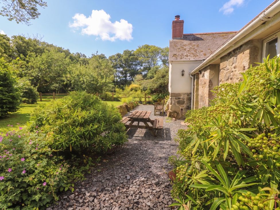 A garden with a table and benches at Swallows in St Keverne, Lizard Peninsula