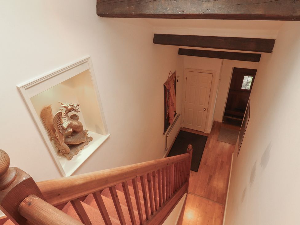 A staircase leading to the hallway with a dragon sculpture at Winster Fields Cartmel Fell near Windermere