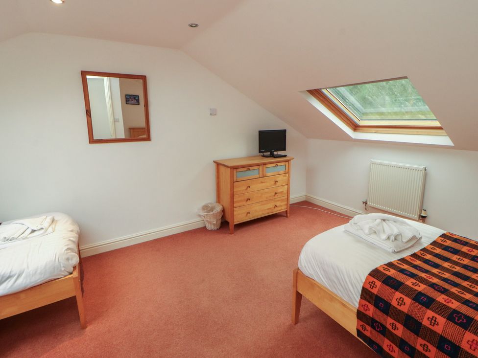 A bedroom with two beds and a dresser at Winster Fields in Cartmel Fell near Windermere