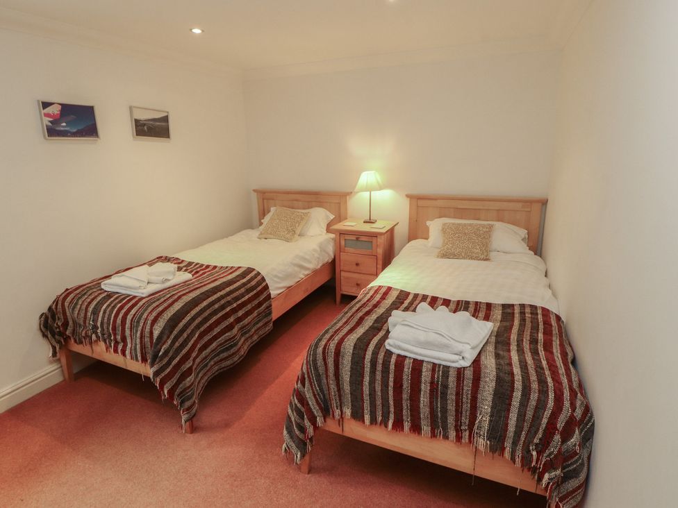 A bedroom with two beds and a nightstand at Winster Fields Cartmel Fell near Windermere